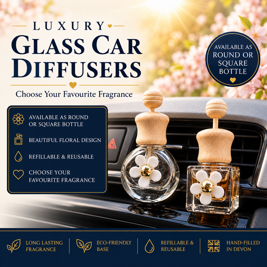 Two luxury glass car diffusers with wooden tops and white flower-shaped glass bottles are displayed on a car dashboard. The image includes promotional text highlighting features such as round or square bottle options, beautiful floral design, refillable & reusable, and choosing your favourite fragrance.